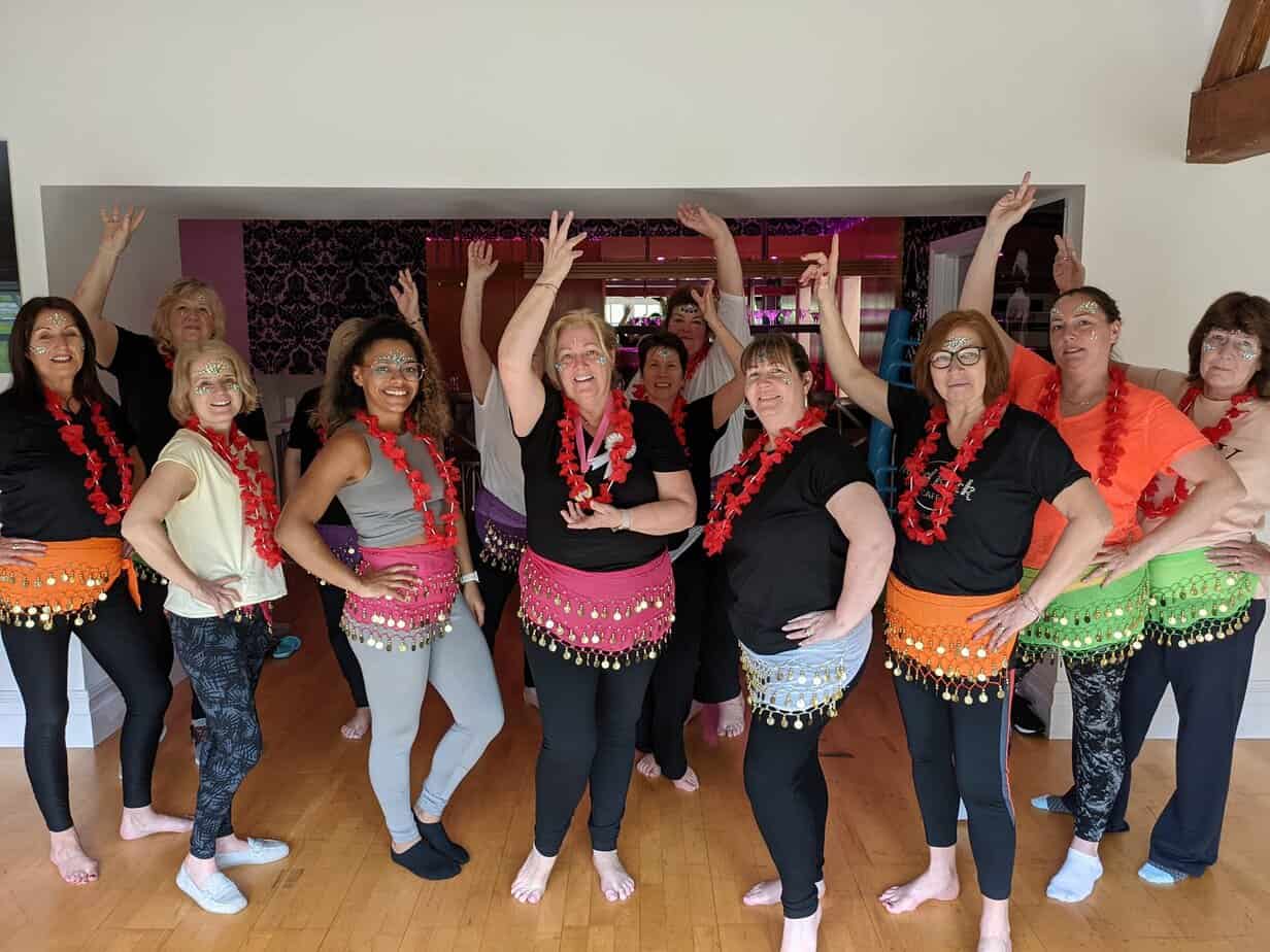 Group of friends at a Bollywood hen party dance class celebrating with vibrant Bollywood hen parties style
