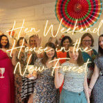Hen weekend house in the New Forest: hen group in the lounge of a country cottage celebrating with a glass for fizz.